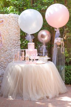 a table topped with a cake and balloons