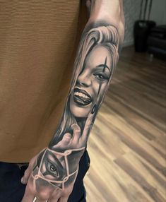 a man with a tattoo on his arm and hand is holding an evil woman's face