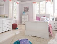 a bedroom with white furniture and pink accessories on the walls, carpeted flooring