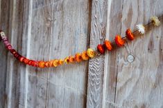 an orange and yellow garland hanging on a wooden wall