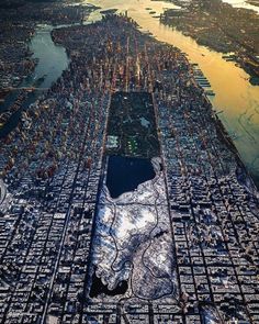 an aerial view of a large city with lots of buildings and water in the foreground