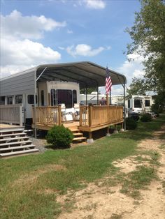 a mobile home with an american flag on the porch and stairs leading up to it