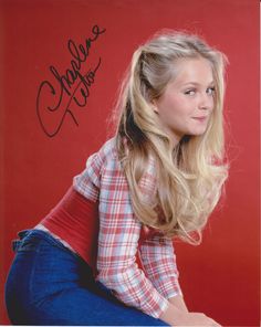 a woman with long blonde hair sitting on the ground