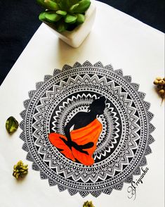 an orange and black design on a white table with succulents next to it