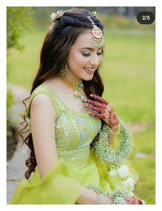 a woman in a green dress is holding her hands together and smiling at the camera