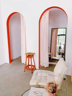 a living room with white walls and orange arches