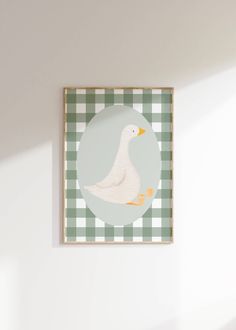 a white duck sitting on top of a green and white checkered tablecloth covered wall