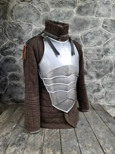 a costume made to look like a knight's armor on display in front of a stone wall