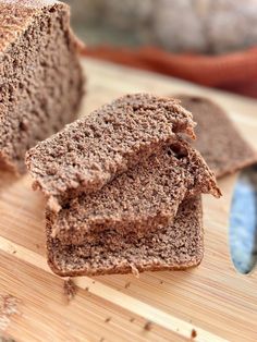 two pieces of brown bread sitting on top of a wooden cutting board