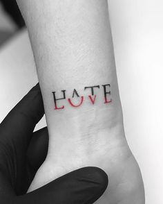 the word love is written in red ink on someone's left wrist and hand