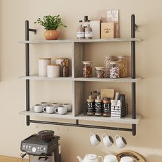 a shelf with coffee cups, teapots and other items on it in a room