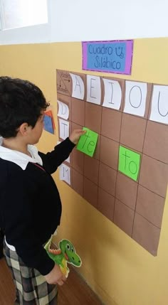 a young boy standing in front of a bulletin board