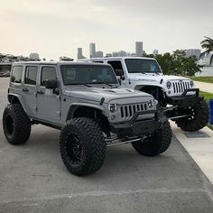 two jeeps parked next to each other in a parking lot