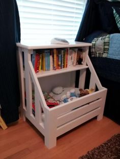 a white book shelf with books on it in a bedroom next to a blue bed