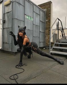 a woman dressed in catwoman costume posing for the camera with her legs spread out