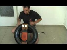 a man sitting on the floor with an inflatable tire