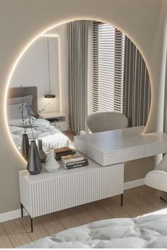 a white bed sitting under a round mirror in a bedroom next to a desk and chair