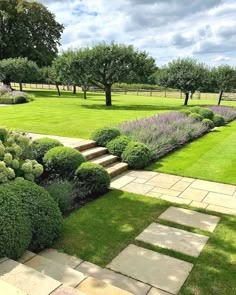 a garden with stone steps and green grass