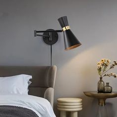 a bedroom with a bed, chair and lamp on the wall next to each other