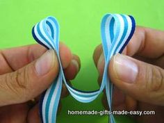 two hands holding blue and white striped ribbon