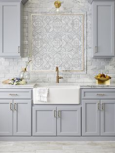 an open magazine showing a kitchen with gray cabinets and white tile backsplashes