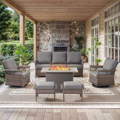 an outdoor living area with furniture and fire pit in the center, surrounded by wood flooring