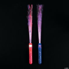 two colorful toothbrushes sitting next to each other on a black surface with writing on them