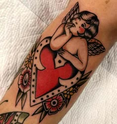 a woman's arm with a heart and angel tattoo design on the left forearm