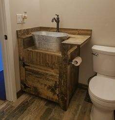 a bathroom with a sink, toilet and wooden cabinet in it's center area