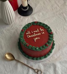 a decorated cake sitting on top of a table next to a spoon and potted plant