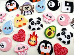 several different types of felt badges on a white surface with animals and letters in them