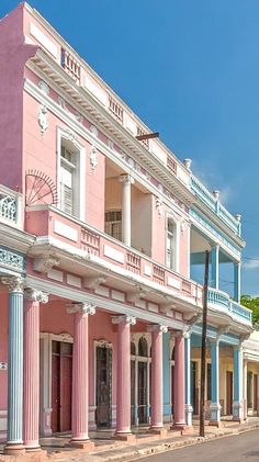 an old pink and blue building with columns on the street in new orleans, florida