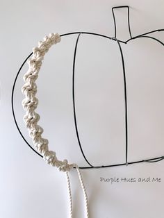 a crocheted pumpkin is shown on the wall next to a string and rope