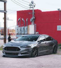 a grey car parked in front of a red building