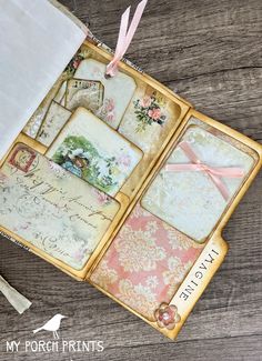 an open book with lots of cards inside it on top of a wooden table next to some papers