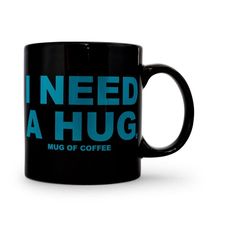 a black coffee mug with the words i need a hug in blue letters on it