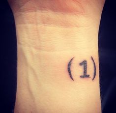 a wrist tattoo with the number one on it