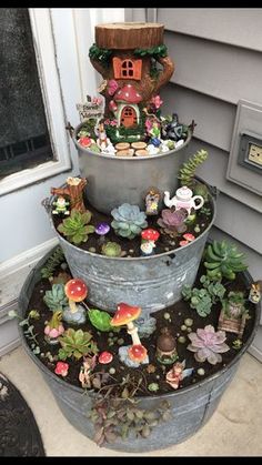 three tiered planters are stacked on top of each other in front of a house