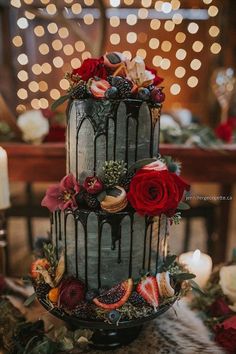 a three tiered cake decorated with flowers and berries