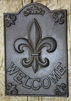 a metal fleur de lis sign mounted on a wooden door with the words welcome to new orleans