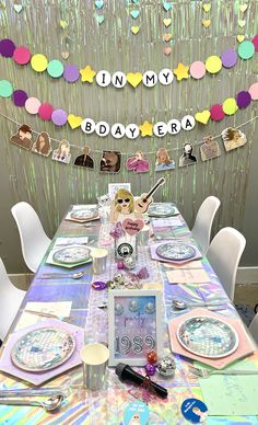 a table set up for a birthday party with plates and napkins on the table