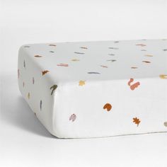 an image of a baby crib sheet with autumn leaves on the top and bottom