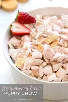 a bowl full of cereal with a strawberry on the top and crackers in the background