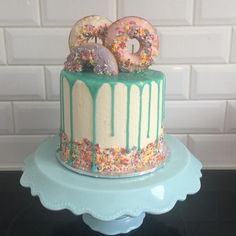 a birthday cake with sprinkles and donuts on top