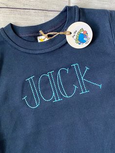 a close up of a shirt with the word jack on it and a small badge