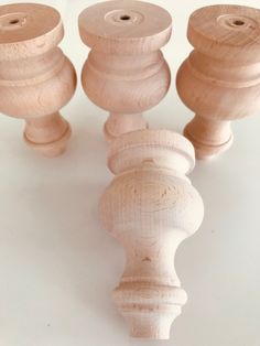 three wooden spools sitting next to each other on top of a white surface