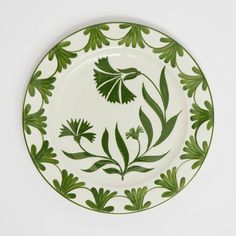 a green and white plate with leaves on it