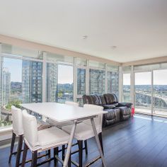 a living room filled with furniture and large windows