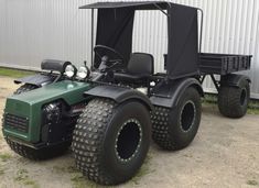 a green four wheeled vehicle parked in front of a building