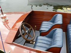 the inside of a boat with two seats and a steering wheel